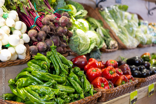 Produce stand with large colorful assortment of fresh organic vegetables arranged in woven baskets  offered for sale in eco products store..