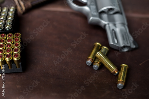 .44 magnum revolver conceal classic gun with bullet on leather background photo