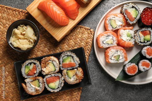 Flat lay composition with delicious sushi rolls on dark grey table