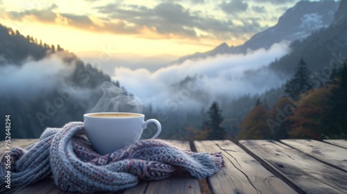 Close-up view of a cup of coffee on table with sunrise over mountain ridge with fog. photo