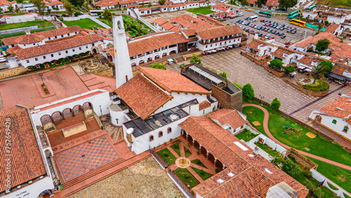 Aerial view of Guatavita, Colombia, showcasing vibrant plaza, traditional architecture, and lush greenery