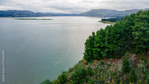 Scenic view of serene Tomin   Reservoir  Guatavita  surrounded by lush greenery under a cloudy sky