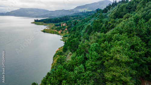 Scenic view of serene Tominé Reservoir, Guatavita, surrounded by lush greenery under a cloudy sky