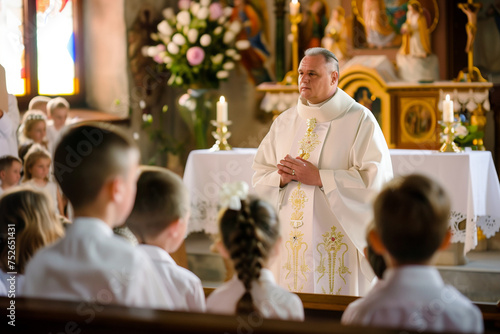 Priest giving mass to a group of children on communion day in a Christian church
