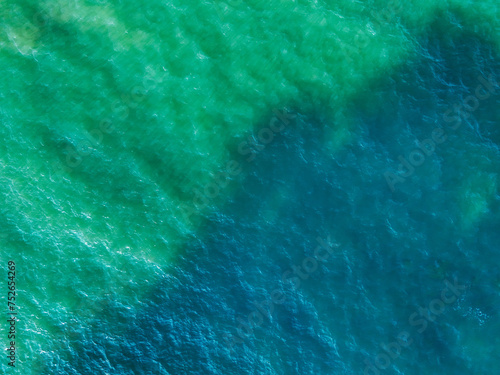 Sea aerial view. Top view of the sea water with the waves of the crashing onto the shore. High angle photo, background water sea natural view, for use as a background for relaxation, travel