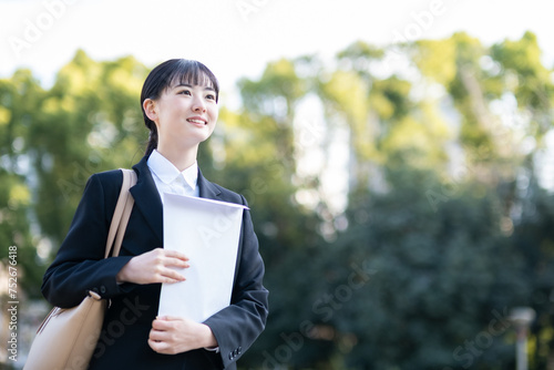 封筒を抱えて歩く就活生