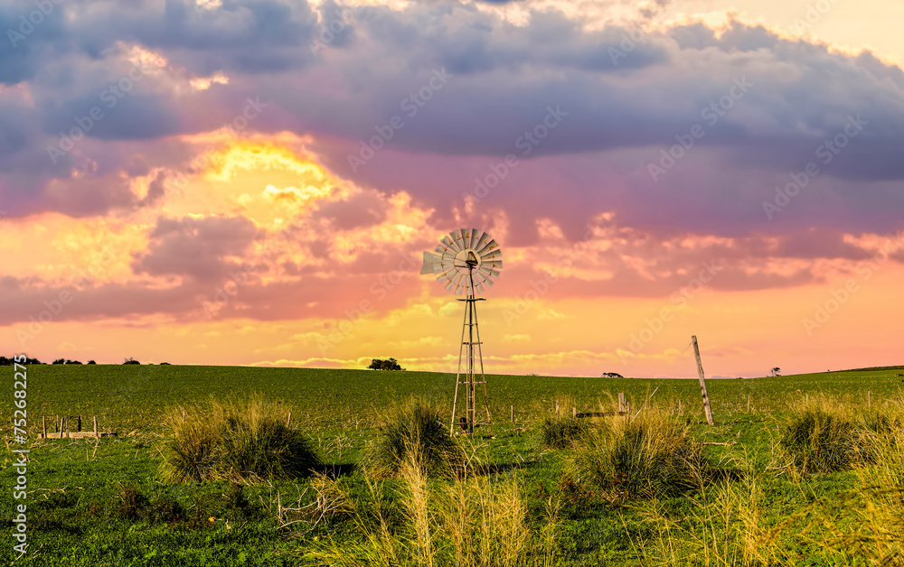 Beautiful old windmill at sunset on Farmland , Western Australia