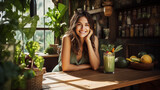 the scene of a radiant young woman with a contagious smile holding a vibrant green smoothie, seated at a rustic wooden table in a sunlit cafe
