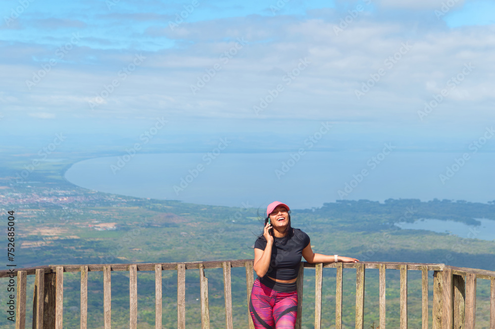 Young latin woman talking on the phone at Mombacho volcano natural reserve