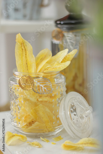 banana chips in a jar with crumbs and blurred foreground and background