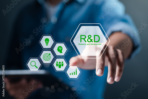 R and D, Research and Development concept. Businessman use tablet with R and D icons on virtual screen. Manage costs more efficiently, Research and development of business science technology.