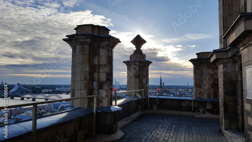 The golden sun rays break through fluffy clouds, casting a warm and radiant glow over the bustling cityscape.