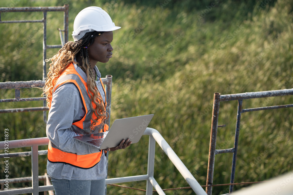 Worker or engineer African woman with holding notebook computer at construction site	