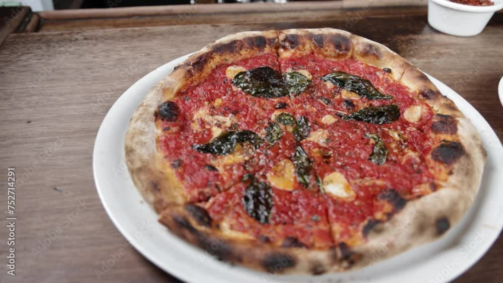 Cooked marinara pizza on a plate inside Pizzeria Bianco in Phoenix, Arizona with video panning moving in a circle. Cooked marinara pizza on a plate inside Pizzeria Bianco in Phoenix, Arizona with video panning moving in a circle.