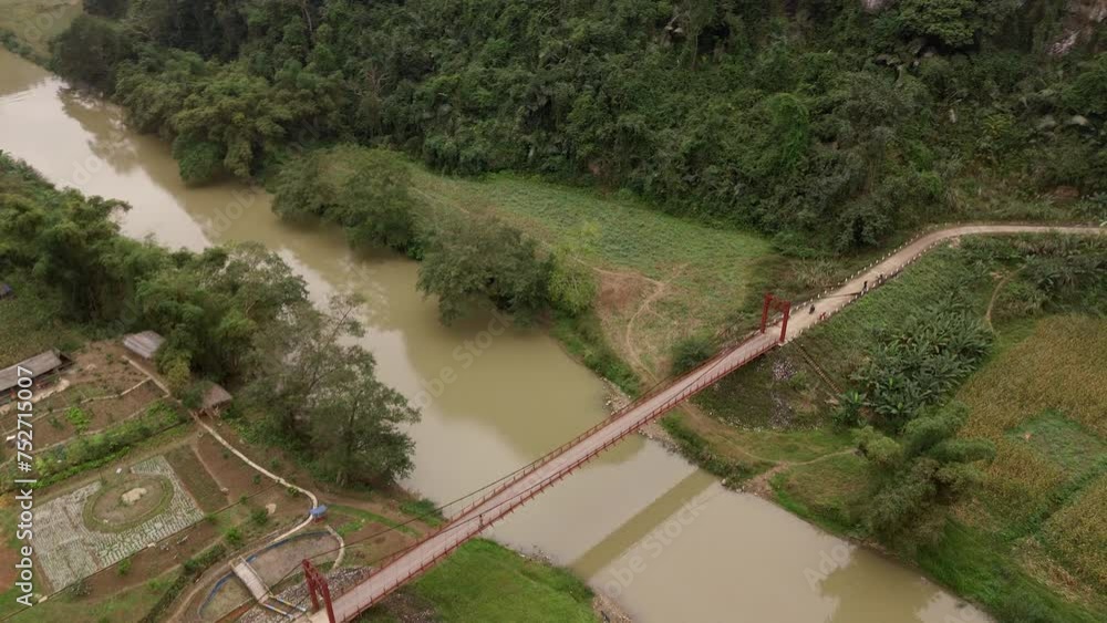A motorbike riding across the bridge over the Nang river and into the jungles of Vietnanm near Puong cave. A motorbike riding across the bridge over the Nang river and into the jungles of Vietnanm near Puong cave.