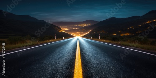 As night descends, an empty highway stretches ahead, its lanes illuminated only by the glow of moonligh photo