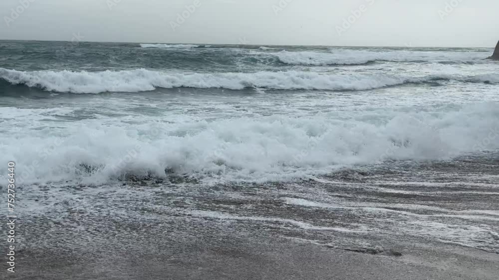 Storm waves over the sand beach. Sea foam Storm waves over the sand beach. Sea foam