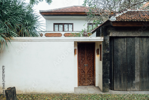 Wooden doorway and white exterior wall of Balinese style building © LI