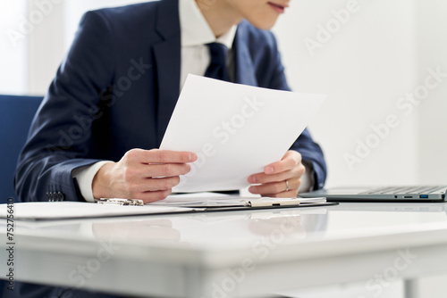 書類の内容を調べるビジネスマン photo