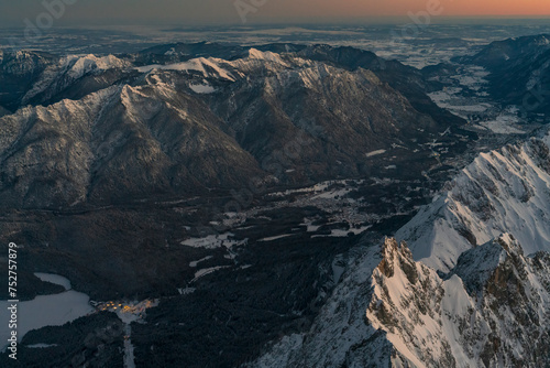 View from the German highest point called Zugspitze mountain down to the Bavarian village Garmisch Partenkirchen and Grainau during sunrise phase