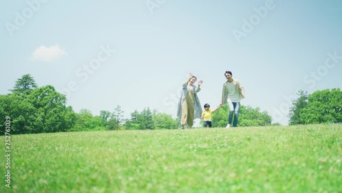 緑の丘で遊びまわる家族