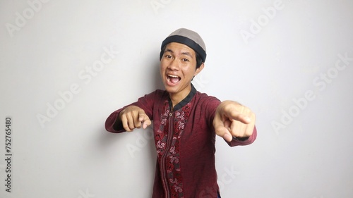 excited asian muslim man gesturing pointing forward