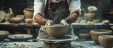 Artisan creating pottery in sunlit rustic workshop