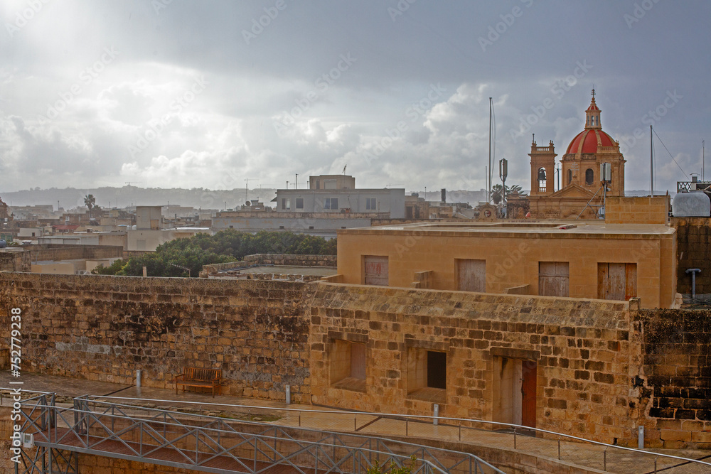 Narrow street of ancient city Rabat with traditional maltese houses built of limestone, Victoria, Malta
