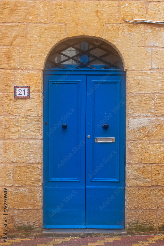 Blue door in house on the street of ancient city Rabat with traditional maltese houses built of limestone, Victoria, Malta