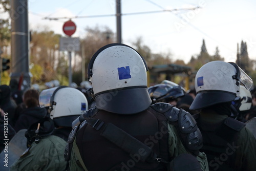 Armed policemen in white protective helmets while control public protest