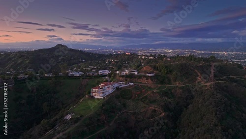 Aerial panorama of homes in Hollywood Hills at dusk, San Fernando Valley cityscape in the background.