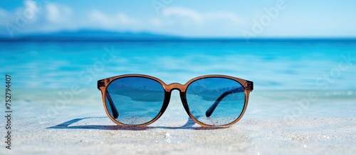 Stylish Sunglasses Resting on Sandy Beach, Exuding a Relaxing Coastal Vibe