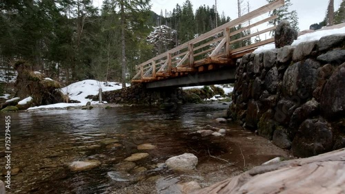 Harmony of nature. Charming view of a winter mountain river and bridge. 4K