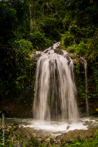 Jungle waterfall cascade in tropical rainforest with rock and turquoise blue pond