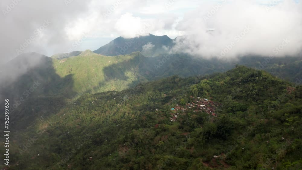 Beautiful remote mountain village in Bali revealed behind fog and clouds, Indonesia Beautiful remote mountain village in Bali revealed behind fog and clouds, Indonesia