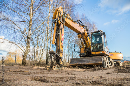 yellow excavator on a sandy construction site