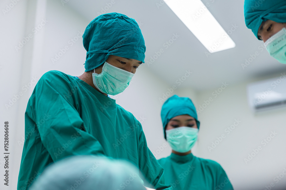 Focused surgeons performing surgery in operating room. Group of surgeons doing surgery in hospital operating theater. Focused surgeons performing surgery in operating room. Group of surgeons doing surgery in hospital operating theater.