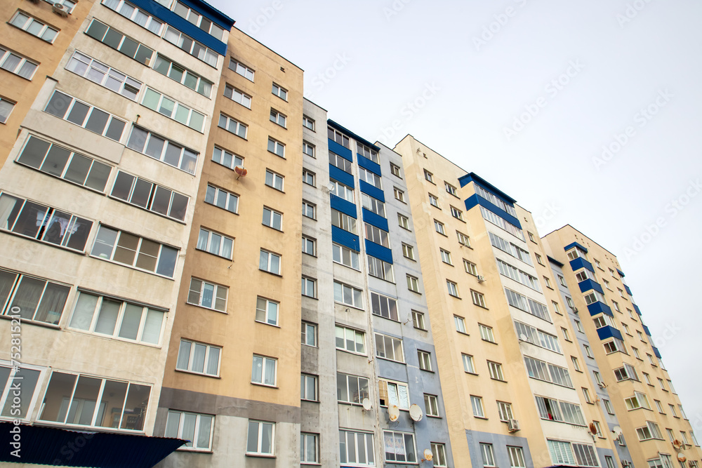 Windows of multi-storey tall building against background of sky