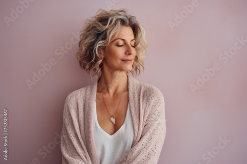 Serene mature woman enjoying tranquility in soft-colored room. Inner peace and self-care.