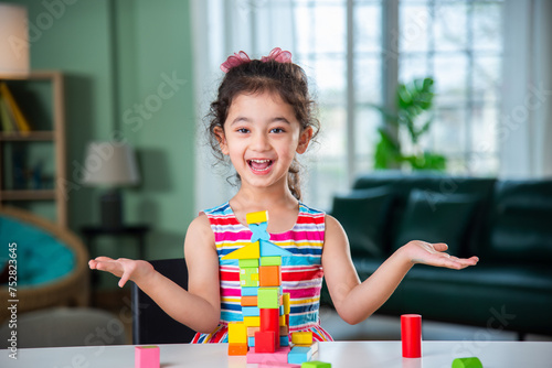 Indian asian child preschooler girl playing wooden toys at home or kindergarten