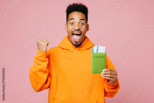 Traveler man wear yellow casual clothes hold passport ticket do winner gesture isolated on plain pink background. Tourist travel abroad in free spare time rest getaway Air flight trip journey concept #752824645