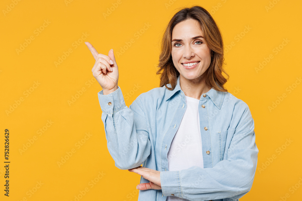 © ViDi Studio - Young smiling happy woman she wearing blue shirt white t-shirt casual clothes point index fingers aside on are mockup workspace isolated on plain yellow background studio portrait. Lifestyle concept. © ViDi Studio - Young smiling happy woman she wearing blue shirt white t-shirt casual clothes point index fingers aside on are mockup workspace isolated on plain yellow background studio portrait. Lifestyle concept.