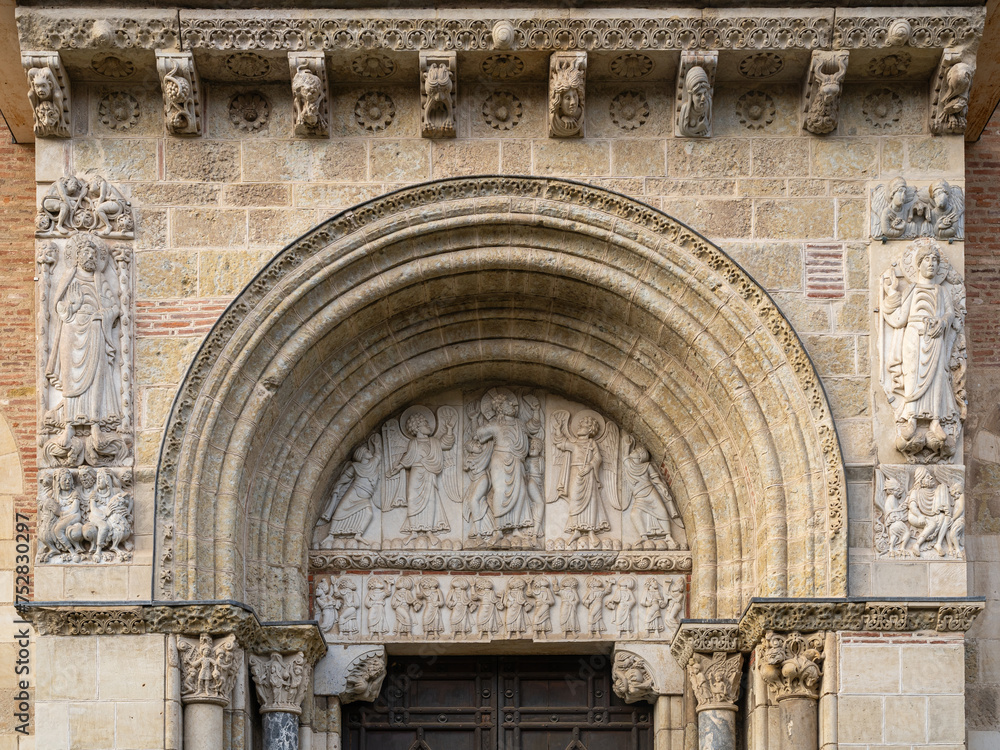 View of the ancient romanesque tympanum representing the Ascension of Christ with angels and the apostles at St Sernin basilica, Toulouse, France