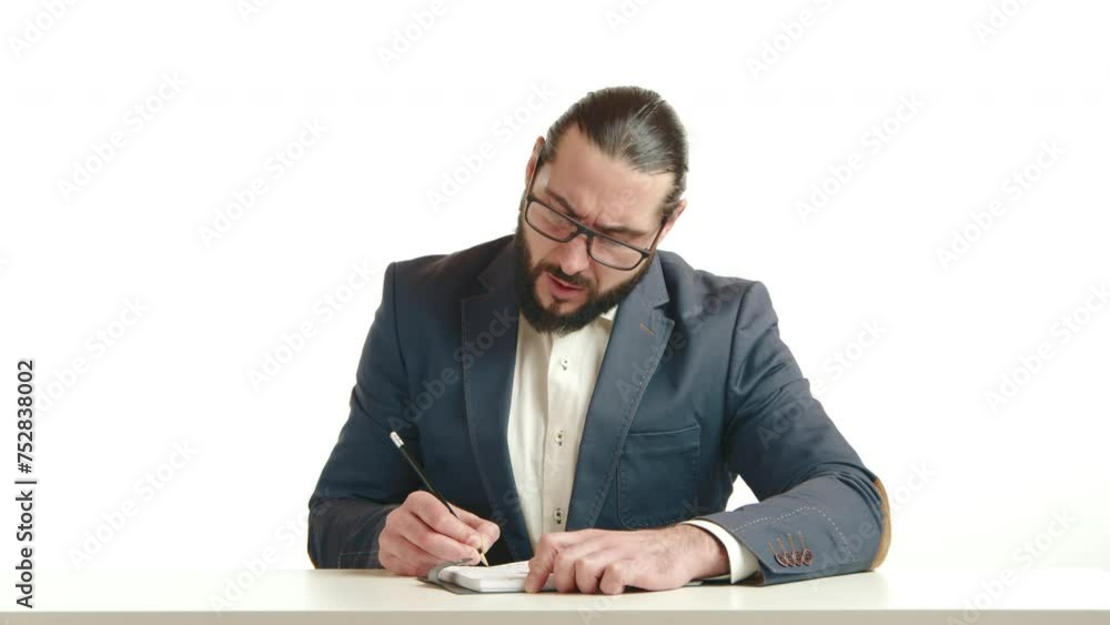 A businessman with a keen focus is meticulously jotting down notes at a white desk, symbolizing dedication and strategic thought in a professional setting. Camera 8K RAW. A businessman with a keen focus is meticulously jotting down notes at a white desk, symbolizing dedication and strategic thought in a professional setting. Camera 8K RAW.