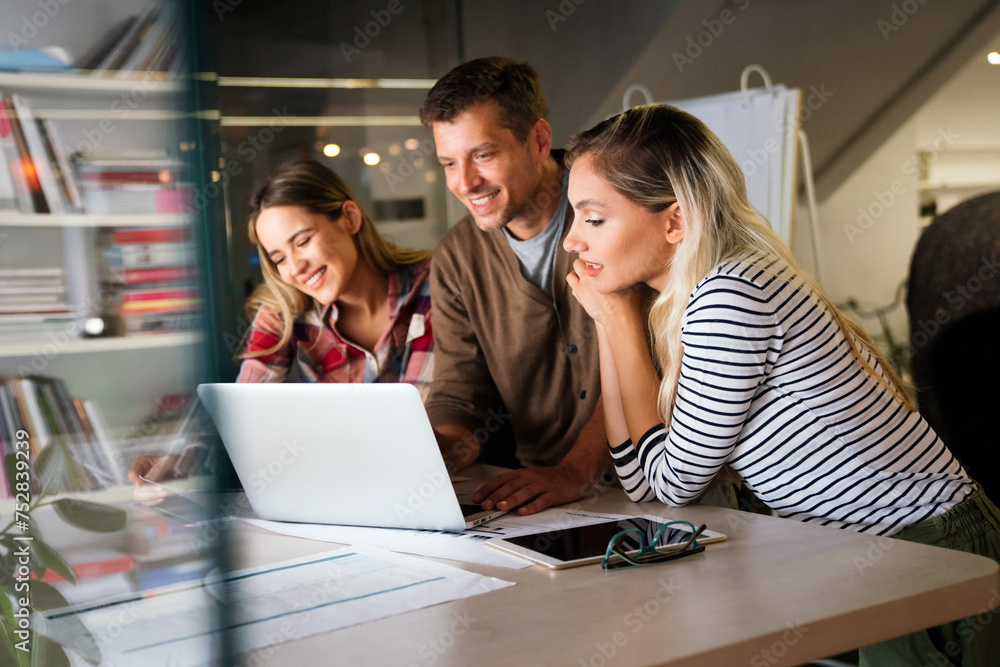 Young manager talking with experienced colleague while using computer in office. Young manager talking with experienced colleague while using computer in office.