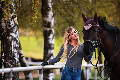 Young woman with long hair and blonde streaks, stands portraits with her horse. © RD-Fotografie
