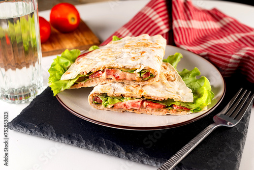 quesadilla with meat, sauce, cheese, tomato and salad leaves.