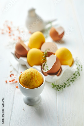 Easter composition with yellow eggs and flowers. Natural dyed colorful eggs and spring flowers rustic composition. Close up. Happy Easter concept.