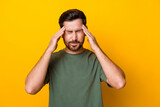 Photo of tired exhausted man wear khaki t-shirt feeling headache arms temples isolated yellow color background