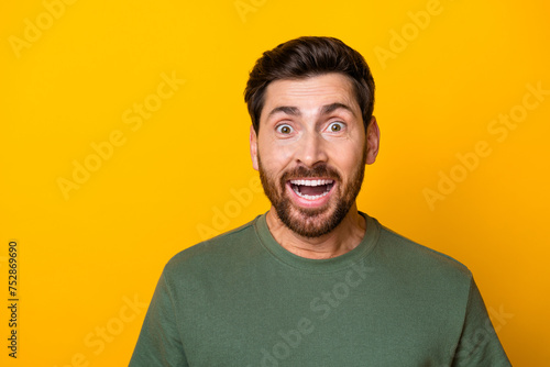 Photo of impressed funky guy dressed green t-shirt open mouth empty space isolated yellow color background